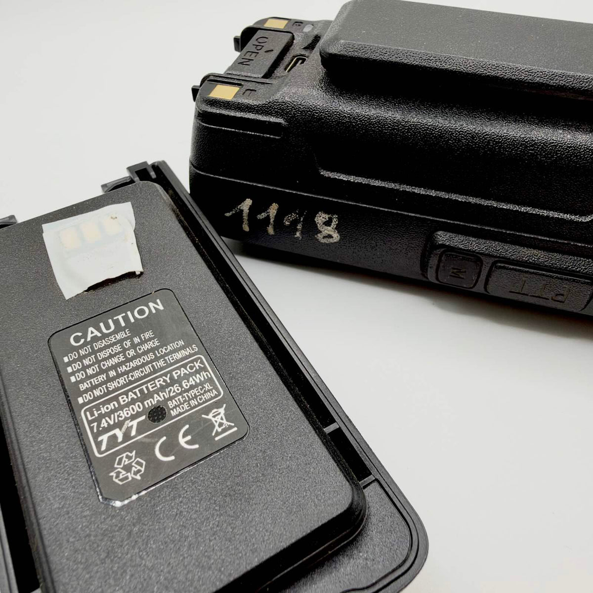 Close-up of the TYT battery label showing 7.4V and 3600mAh, beside the radio’s handwritten identification number.