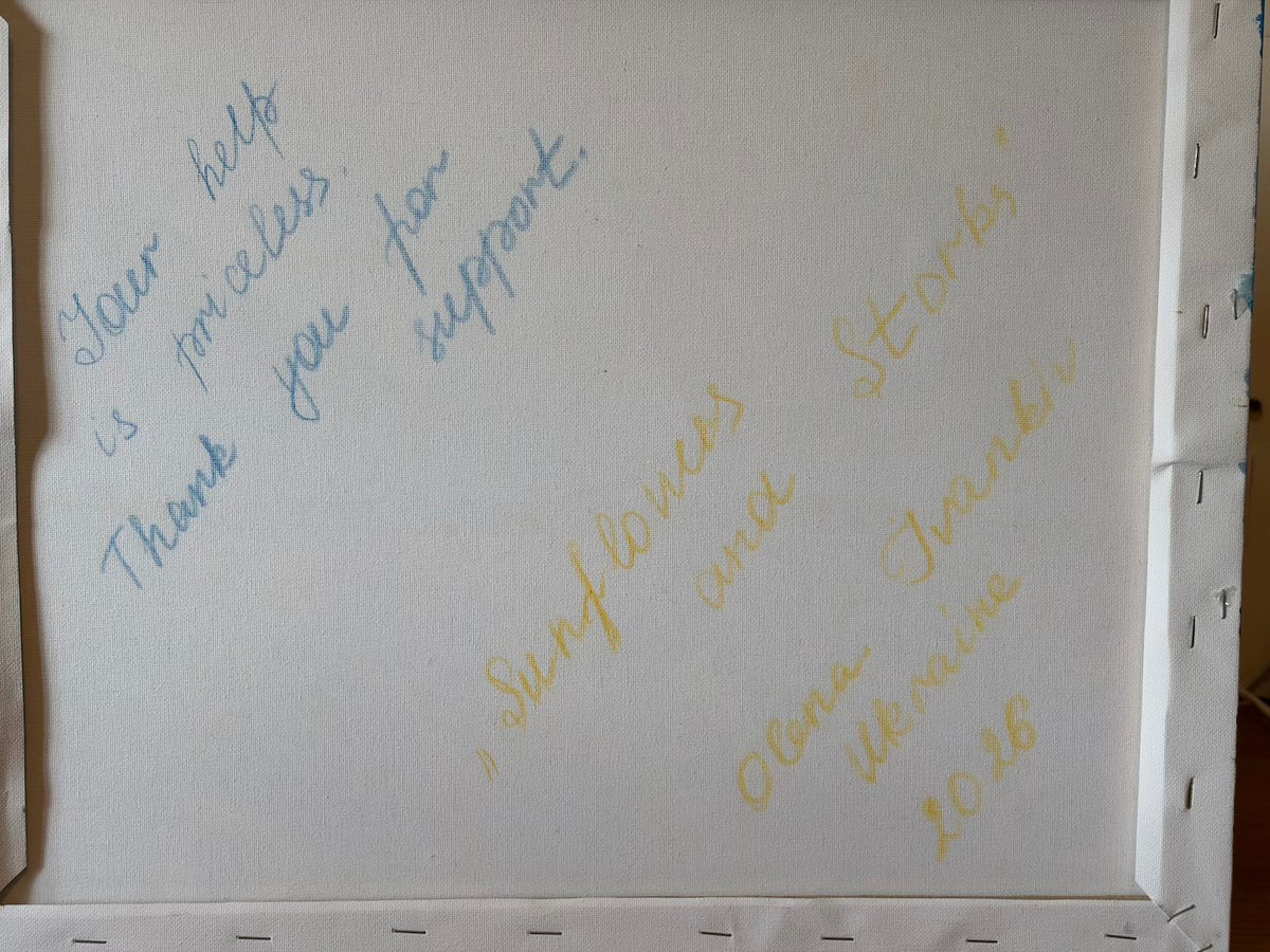 Reverse of the canvas showing its wooden stretcher frame and handwritten message: “Your help is priceless. Thank you for support.” The title “Sunflowers and Storks” appears alongside the signature Olena, Ivankiv, Ukraine, 2026.