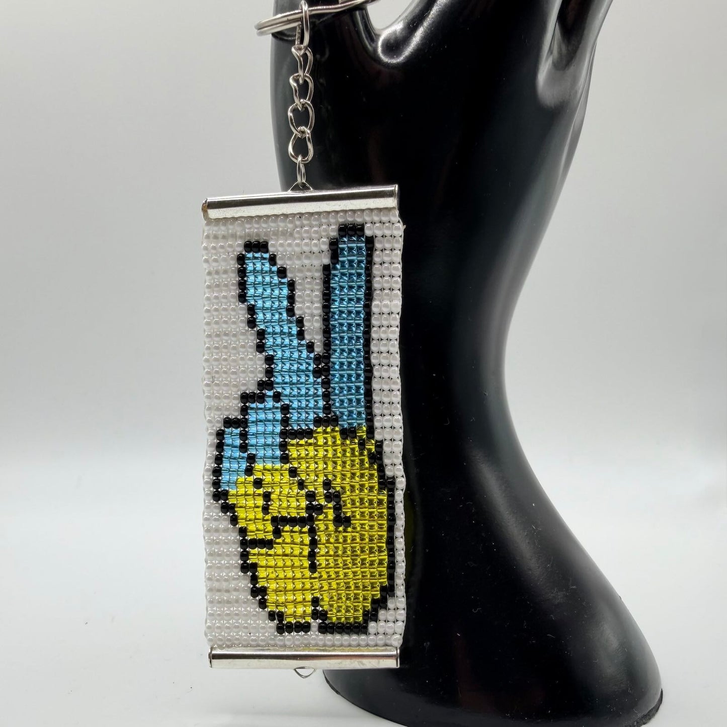 Blue and yellow beaded keyring showing peace sign