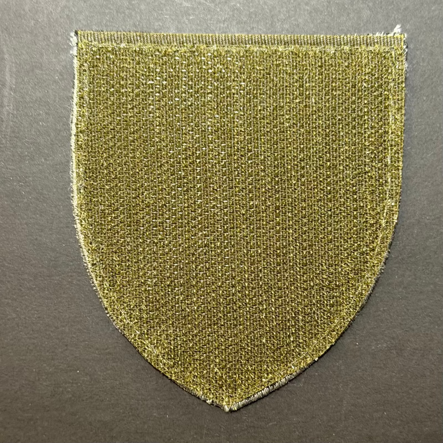 Olive green fabric patch on a gray background