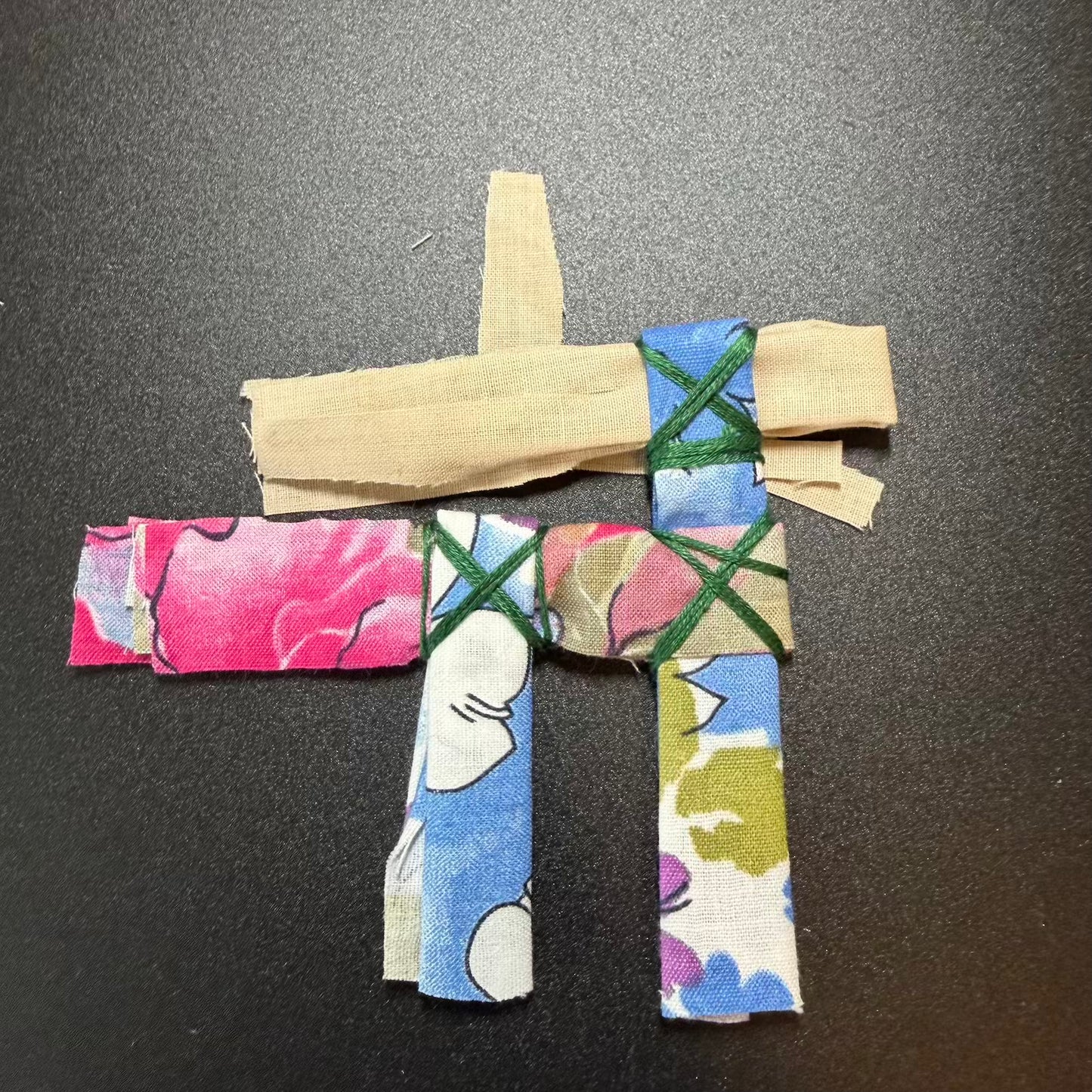 Colorful fabric cross on a dark background