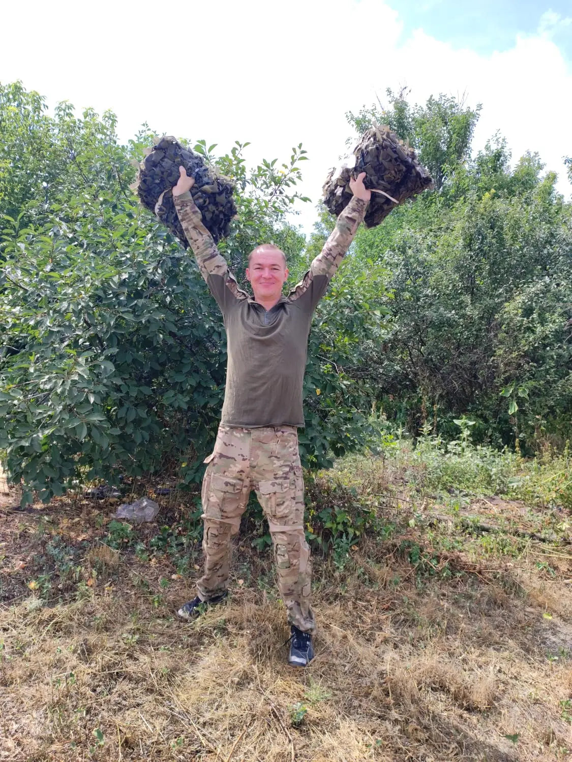 Group of people posing in front of a decorative wall with a blue and yellow heart design, likely representing Ukraine.