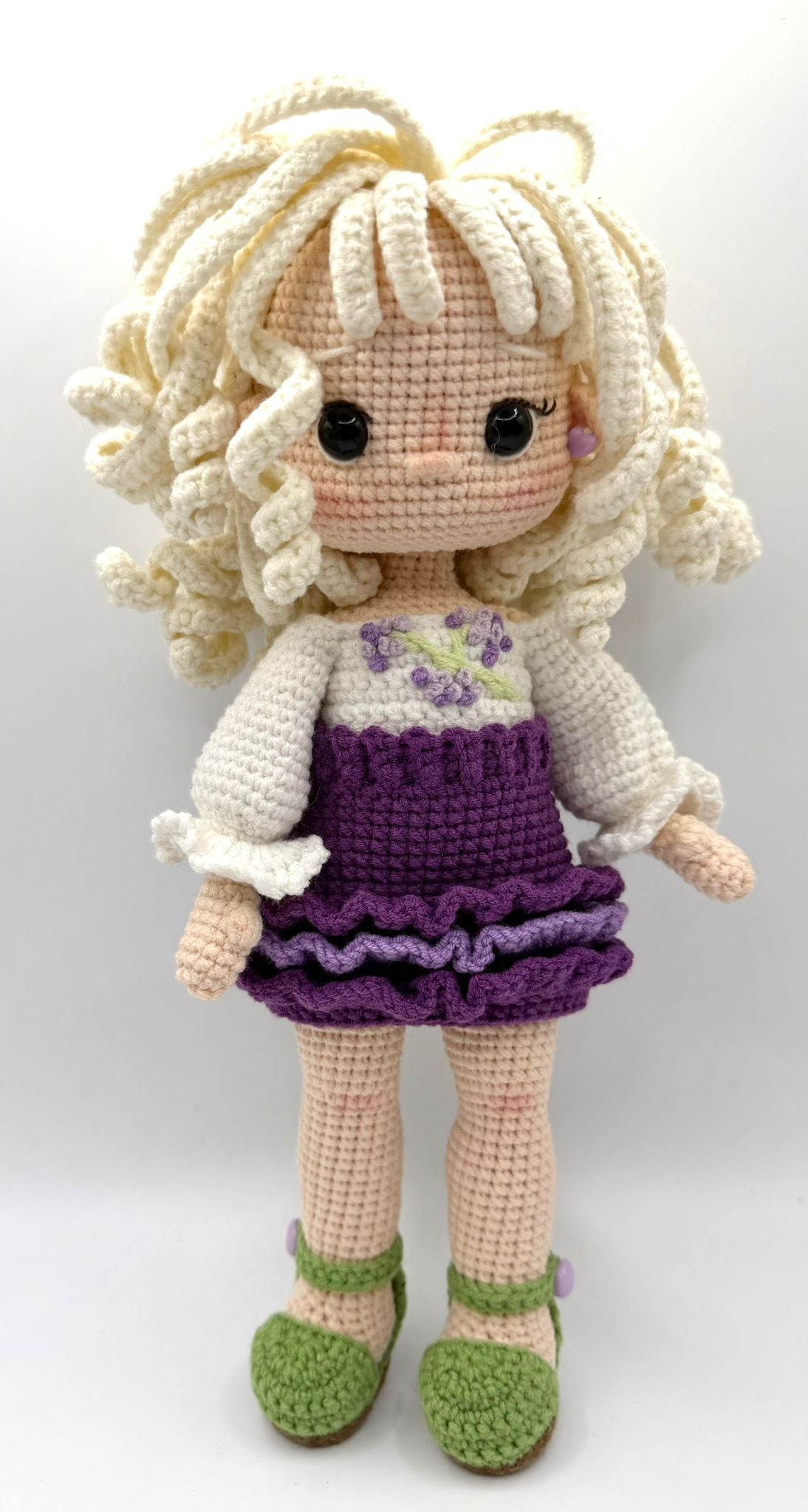 Knitted Doll girl with blonde hair and a purple and white dress with green shoes