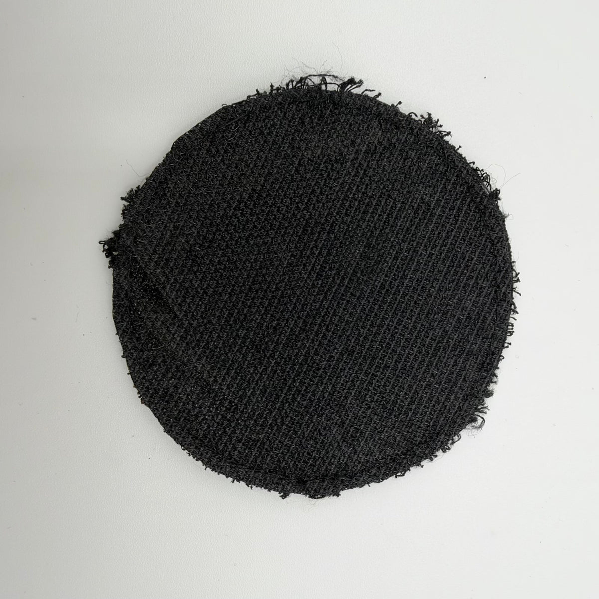 Reverse of the circular FREELANCER trophy patch, showing black textured backing and frayed edges.