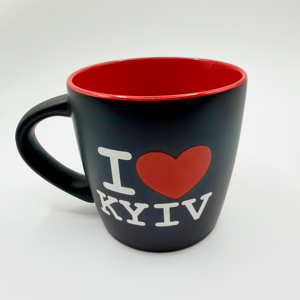 Black “I Love Kyiv” mug with white lettering, a red heart, bright red interior and rim, and a black curved handle.
