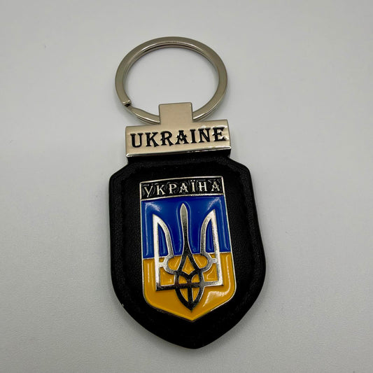 Ukraine keyring with a silver-tone Tryzub over a blue and yellow shield, black stitched backing, bilingual lettering and a metal split ring.