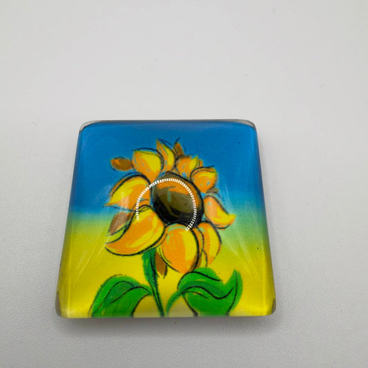 Rectangular acrylic fridge magnet with rounded corners, featuring a yellow sunflower with green leaves against a blue and yellow background.