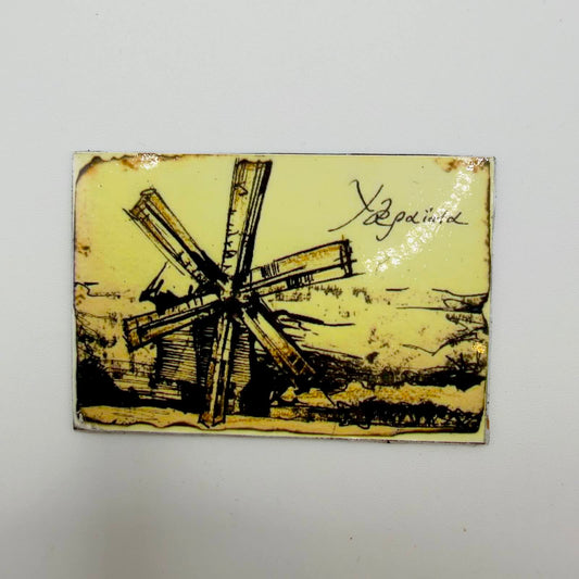 Rectangular fridge magnet with a sepia-style drawing of a wooden windmill in a rural landscape and “Ukraine” written in Ukrainian script.