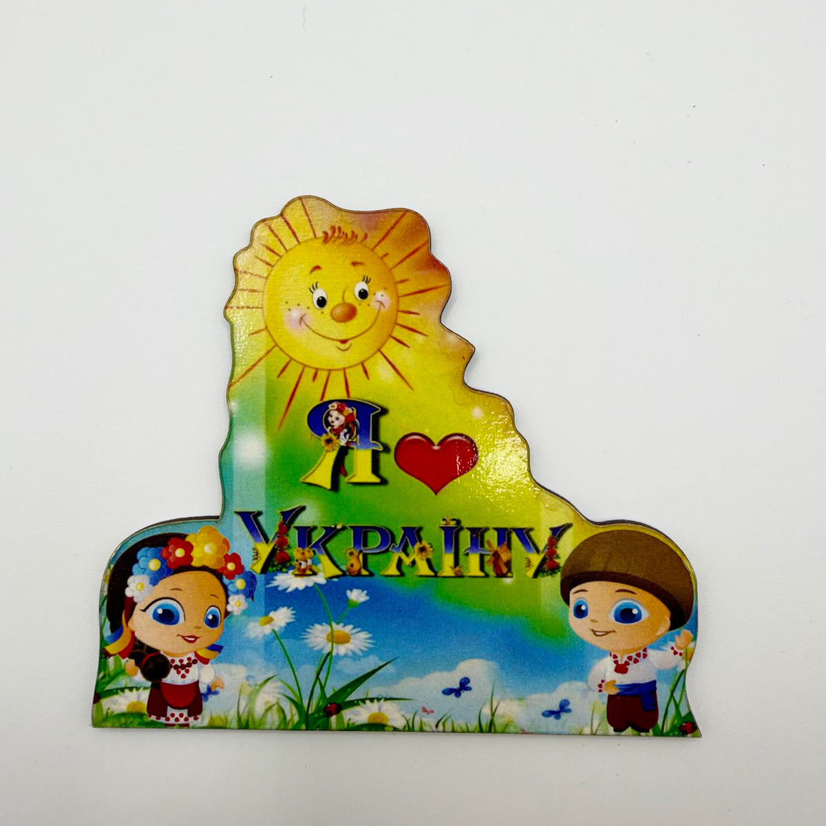 Colourful “I love Ukraine” fridge magnet with a smiling sun, two cartoon children in traditional Ukrainian dress, daisies and butterflies.