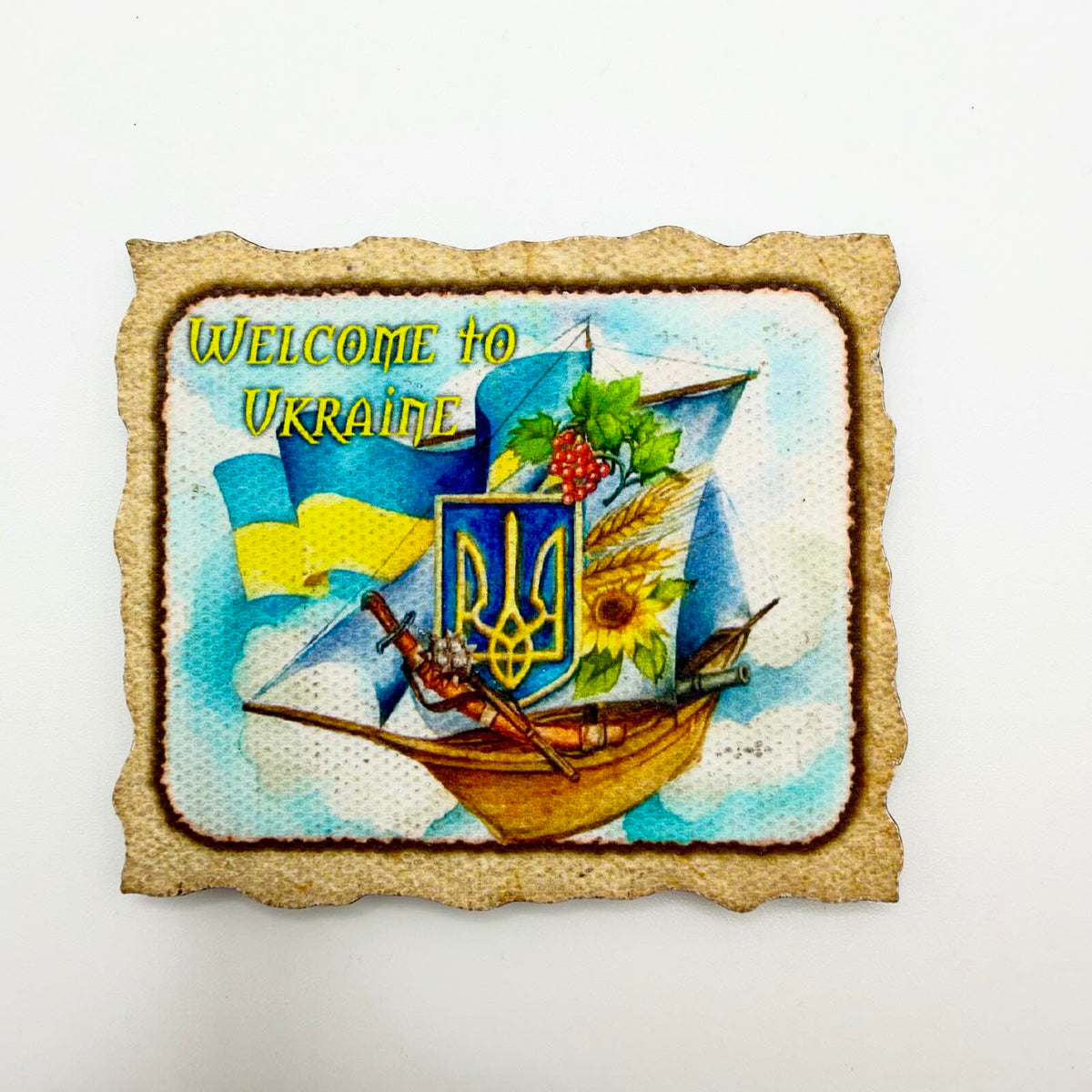 “Welcome to Ukraine” fridge magnet with a sailing boat, Ukrainian flag, Tryzub shield, sunflower, wheat and red berries inside a parchment-style border.