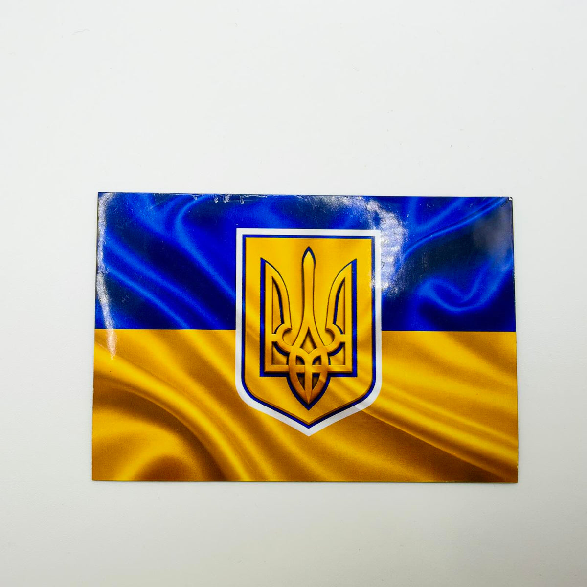 Large rectangular fridge magnet featuring a blue and yellow Ukrainian flag with a rippling fabric effect and central gold-coloured Tryzub shield.