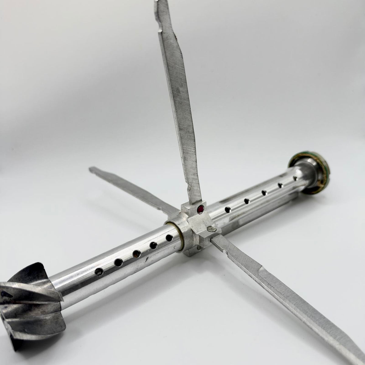 Inert RPG-7-pattern tail stabiliser with its four long fins extended around the central tube and smaller curved vanes at the rear.