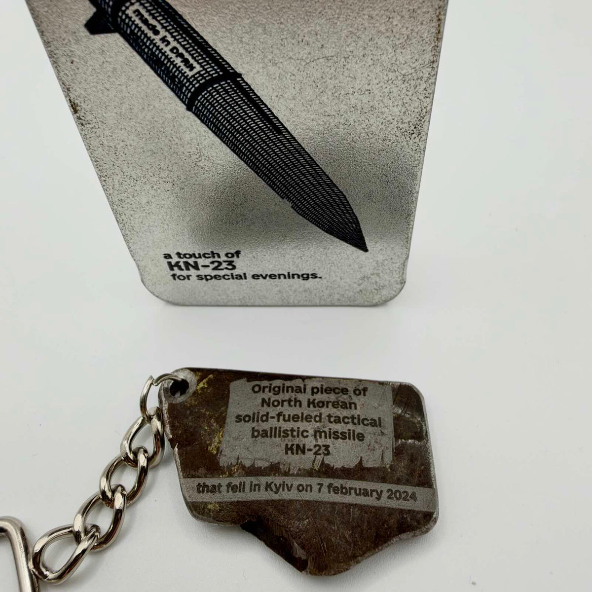 Thick metal fragment keyring with an inscription identifying a North Korean KN-23 missile that fell in Kyiv on 7 February 2024.