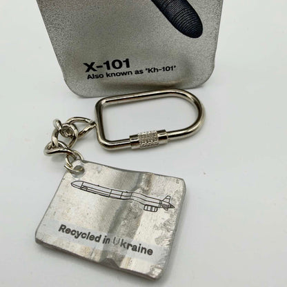 Metal missile fragment keyring with a missile outline and “Recycled in Ukraine” inscription, attached to a short chain and screw-closure fitting.