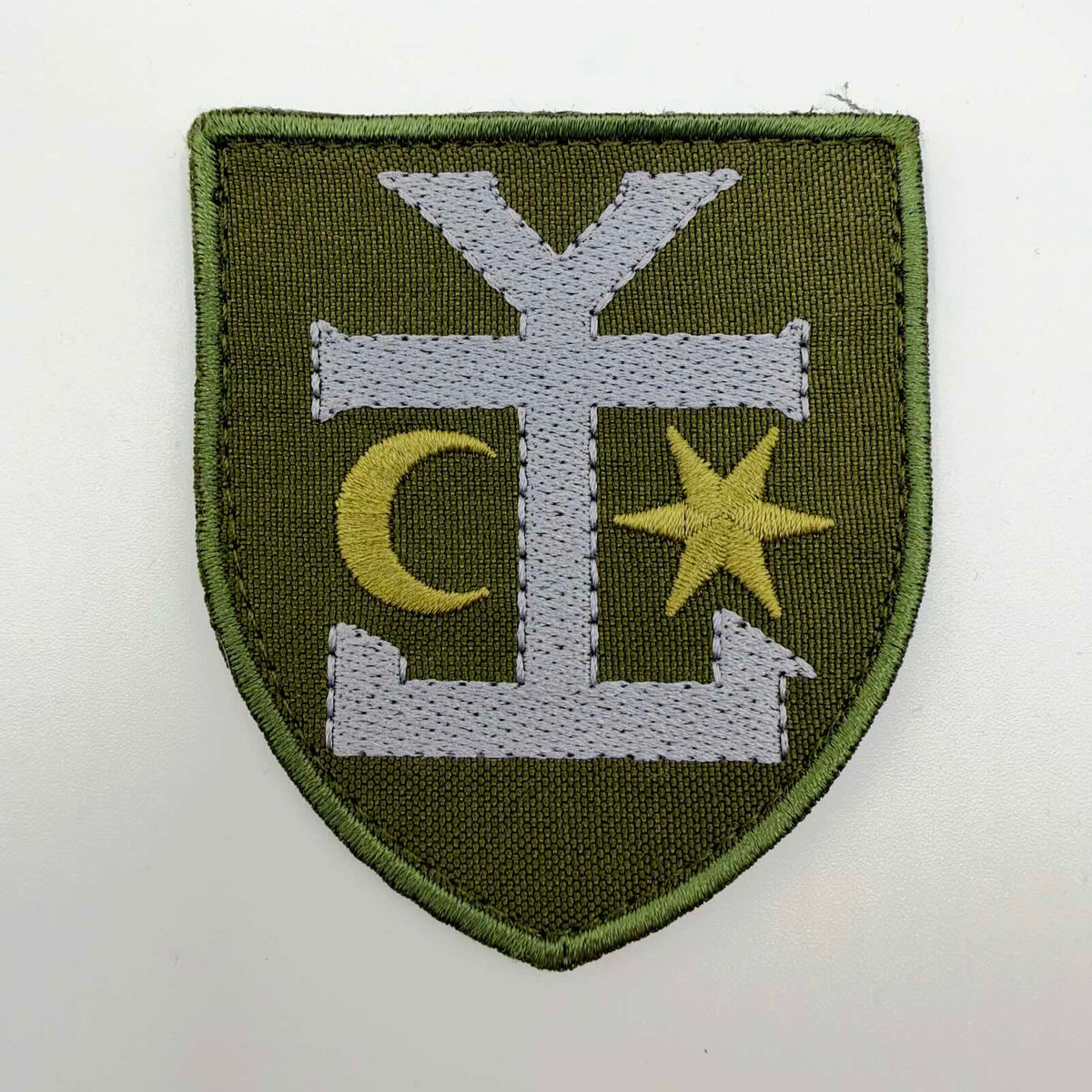 Olive-green shield-shaped embroidered patch of Ukraine’s 54th Separate Mechanised Brigade, featuring Ivan Mazepa’s silver-coloured heraldic symbol between a golden crescent and six-pointed star.