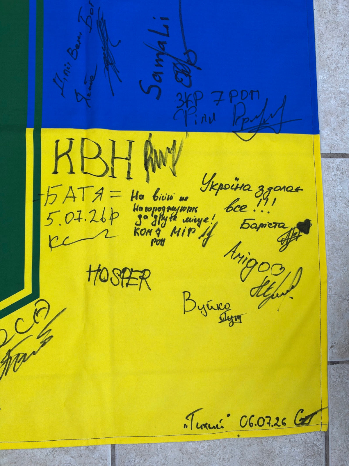 Close-up of messages meaning “Ukraine will overcome everything” and “In war, there are no awards for second place,” surrounded by callsigns and signatures.