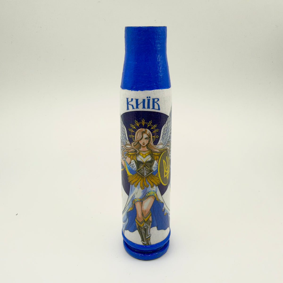 Decorated shell casing with a blue neck and base, white body, and Kyiv lettering above a winged female guardian holding a shield with a gold Ukrainian trident.