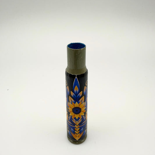 Decorated casing with an olive-green neck and base, featuring a yellow sunflower with a blue centre and symmetrical blue and gold foliage on a dark background.