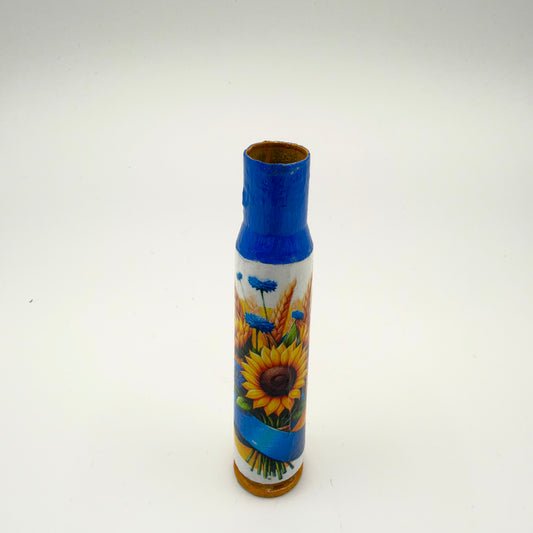 Decorated casing with a blue neck and golden-brown base, showing a yellow sunflower, blue cornflowers and golden wheat tied with a blue and yellow ribbon.