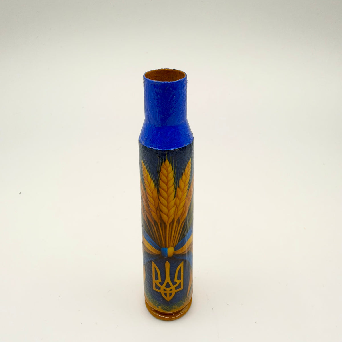 Decorated casing with a bright blue neck and golden-yellow base, showing golden wheat tied with a blue and yellow ribbon above a golden Ukrainian trident on dark blue.