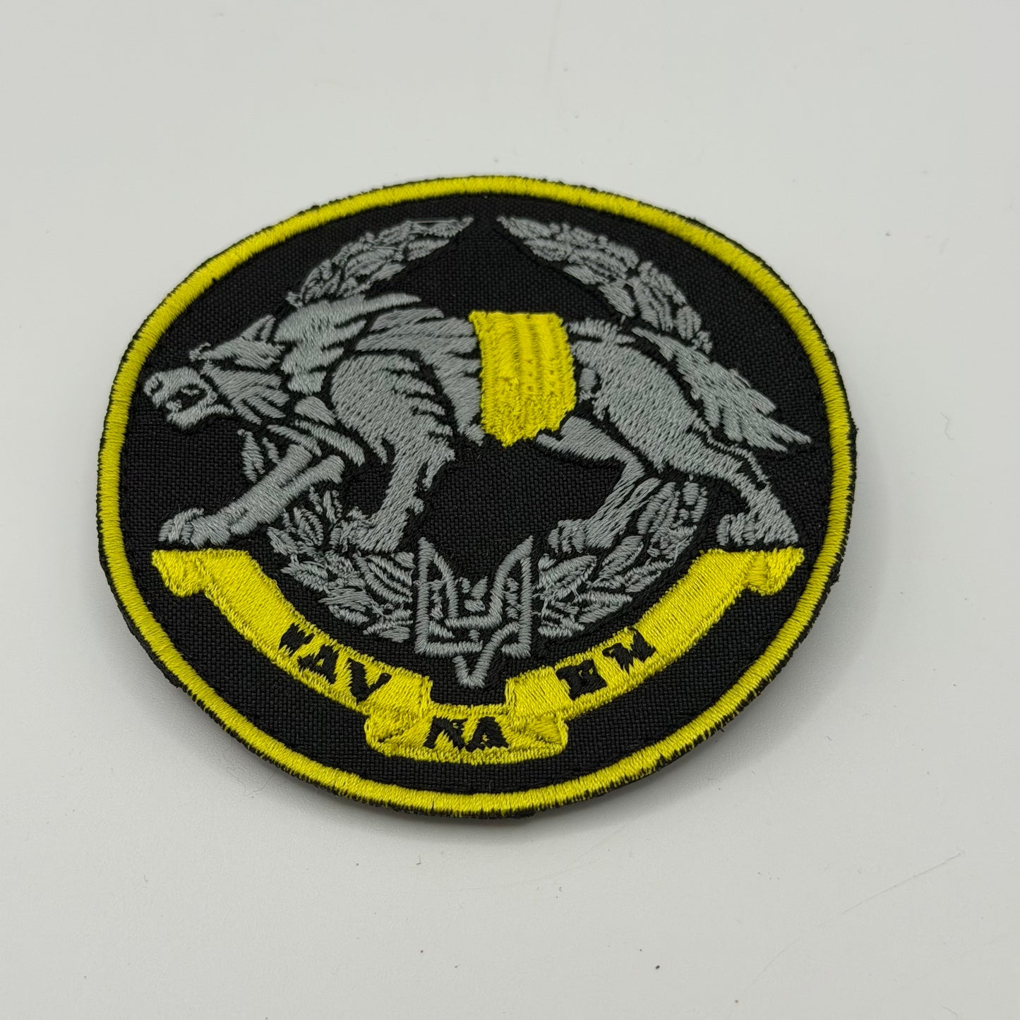 Black and Gold patch depicting a Wolf with a stylized Ukrainian trident (Tryzub) within a laurel wreath and the motto "ІДУ НА ВИ" (I go to you)