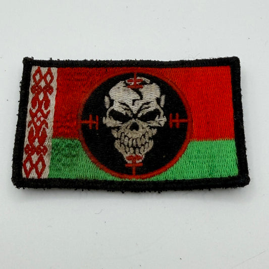 Rectangular Velcro patch showing Red and green background with a skull in crosshairs