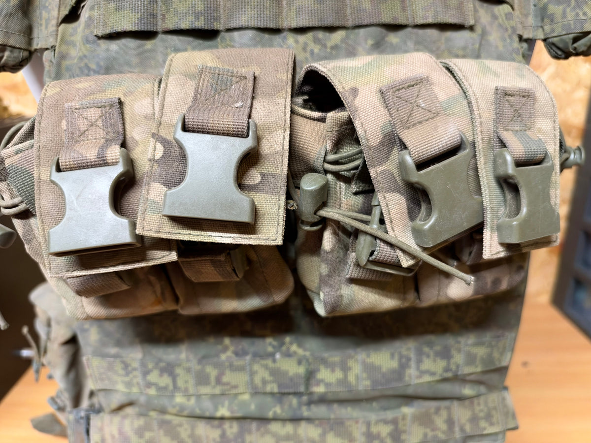Front ammunition pouches attached to the captured Russian vest, showing plastic buckles and elastic retainers.
