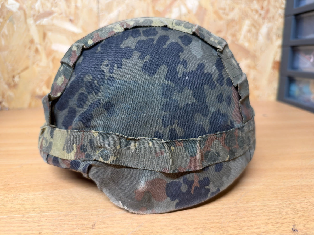 Left-side view of the probable Spanish MARTE III helmet with its faded and field-worn German Flecktarn camouflage cover.