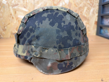 Left-side view of the probable Spanish MARTE III helmet with its faded and field-worn German Flecktarn camouflage cover.