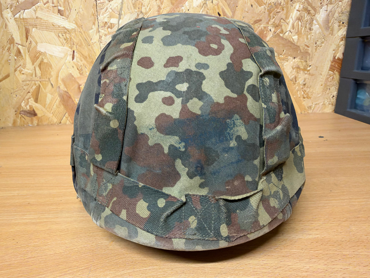 Front view of the probable Spanish MARTE III helmet with its distinctive shape and worn Flecktarn camouflage cover.