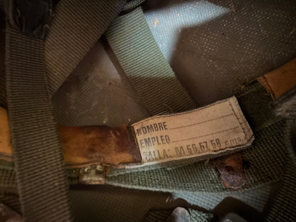 Spanish-language internal label reading “Nombre / Empleo / Talla” and identifying the military helmet as medium size 56–58 cm.