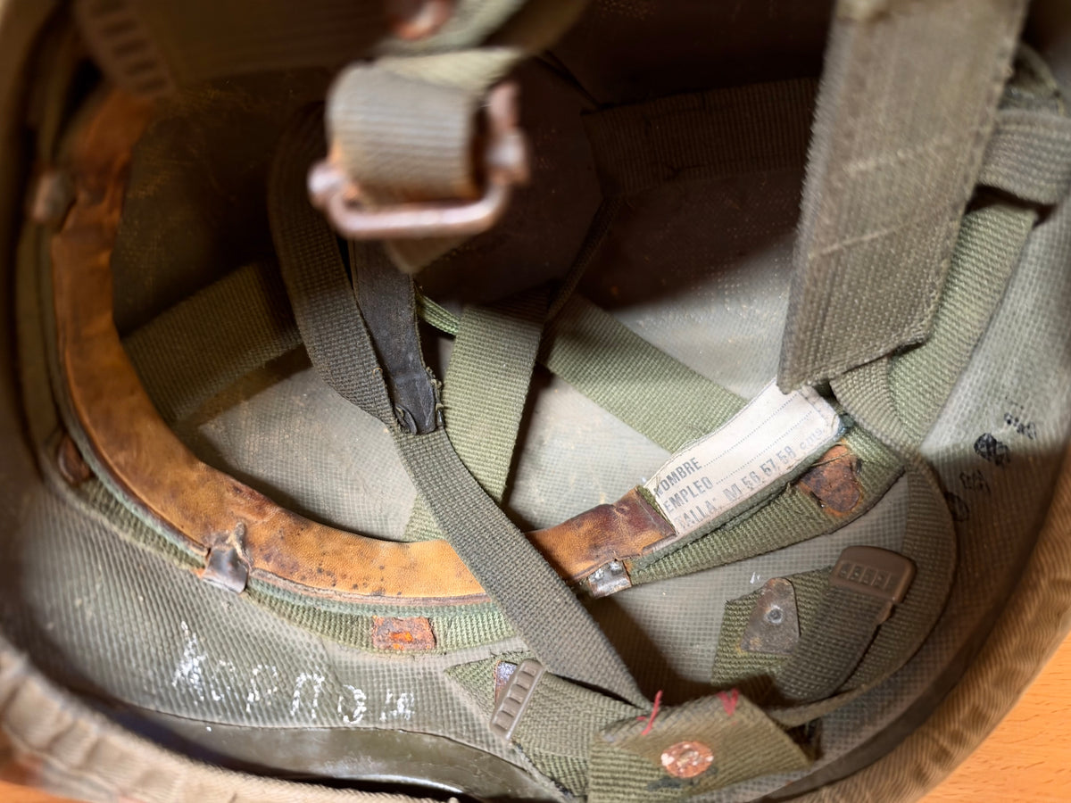 Interior view of the used helmet showing its suspension straps, Spanish size label and heavily worn leather liner.