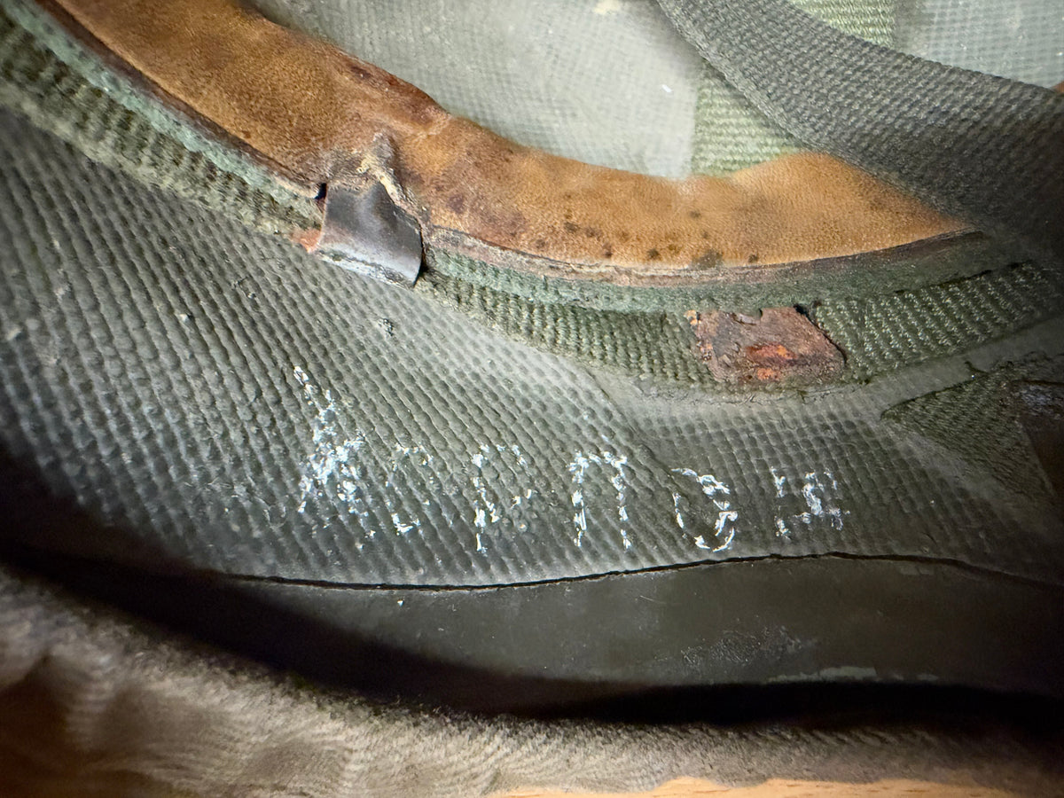 Close-up of the worn internal rim and faint “MARTE 03/95” marking inside the Spanish composite helmet.