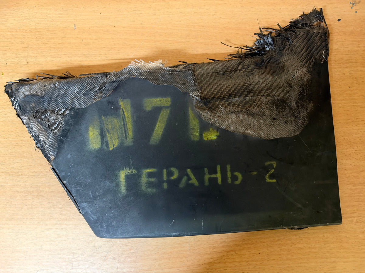 Front view of the lower vertical stabiliser from a Russian Geran-2 drone, displaying the yellow “ГЕРАНЬ-2” designation and partial “M7…” marking.