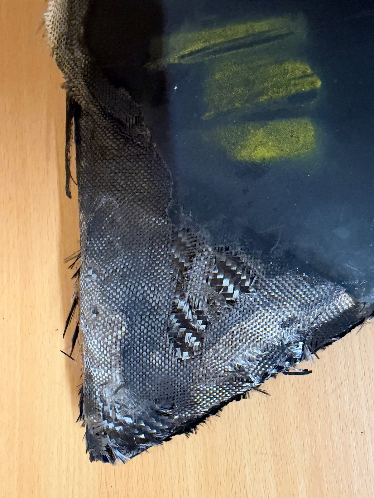 Detailed view of exposed composite layers and impact damage beside the yellow stencil on the recovered Geran-2 stabiliser.