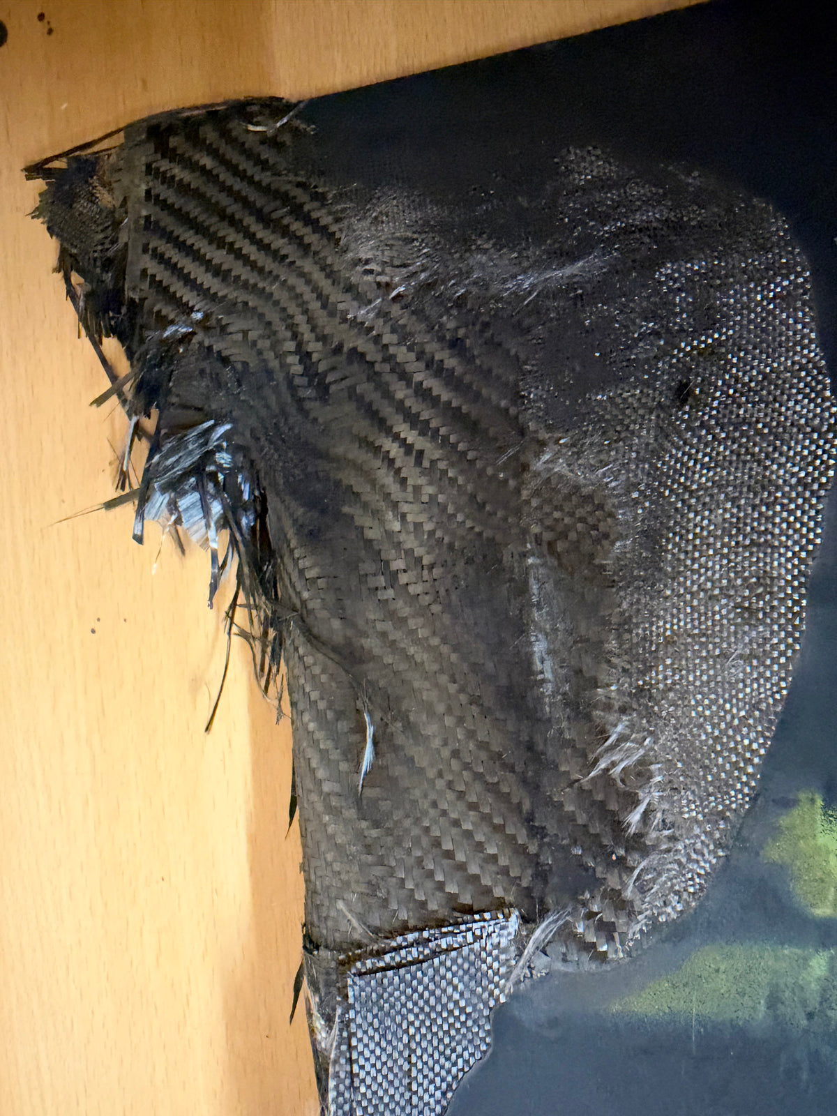 Close-up of torn woven composite material and loose fibres on the damaged lower stabiliser recovered from a Russian Geran-2 attack drone.