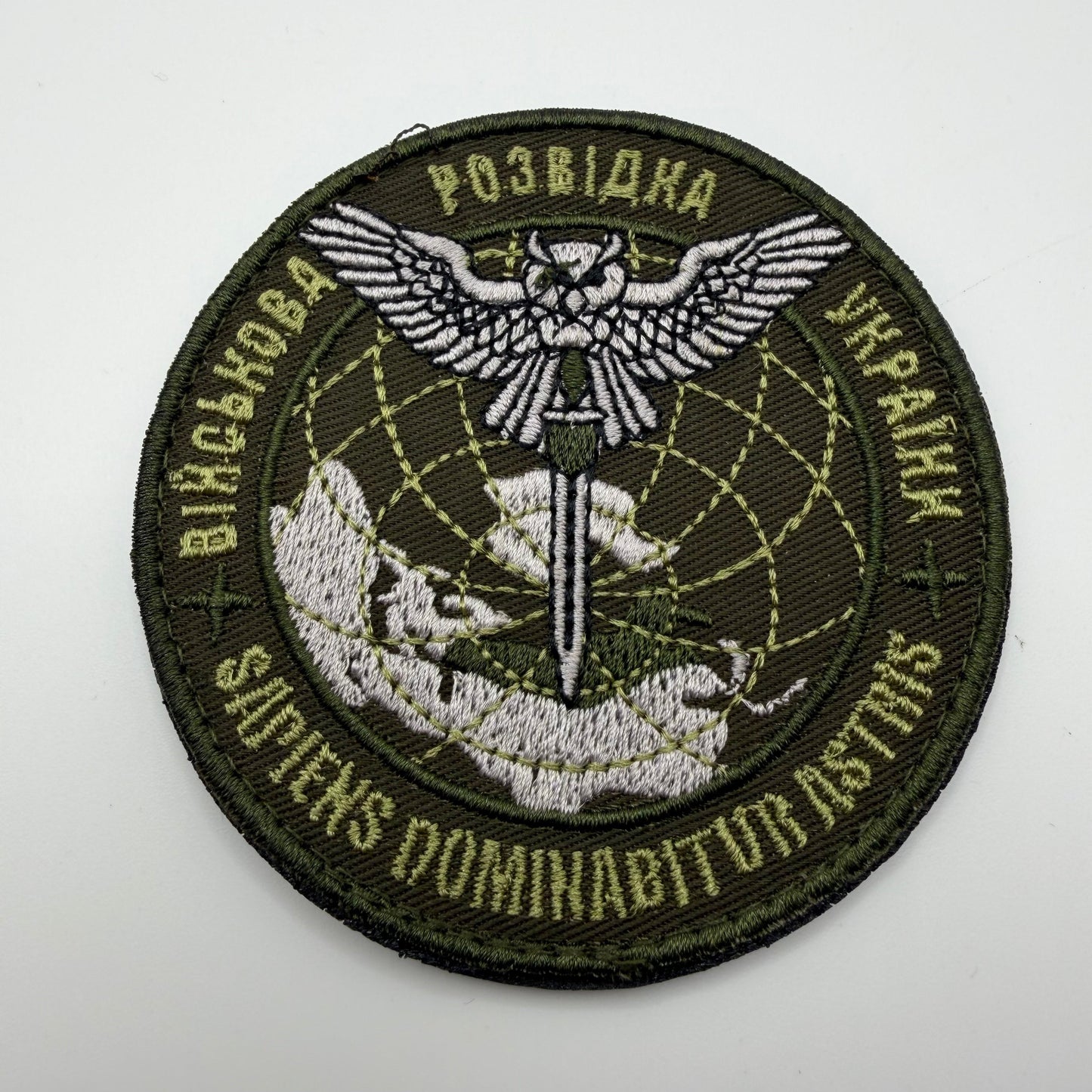 Circular patch with embroidered design on a white background