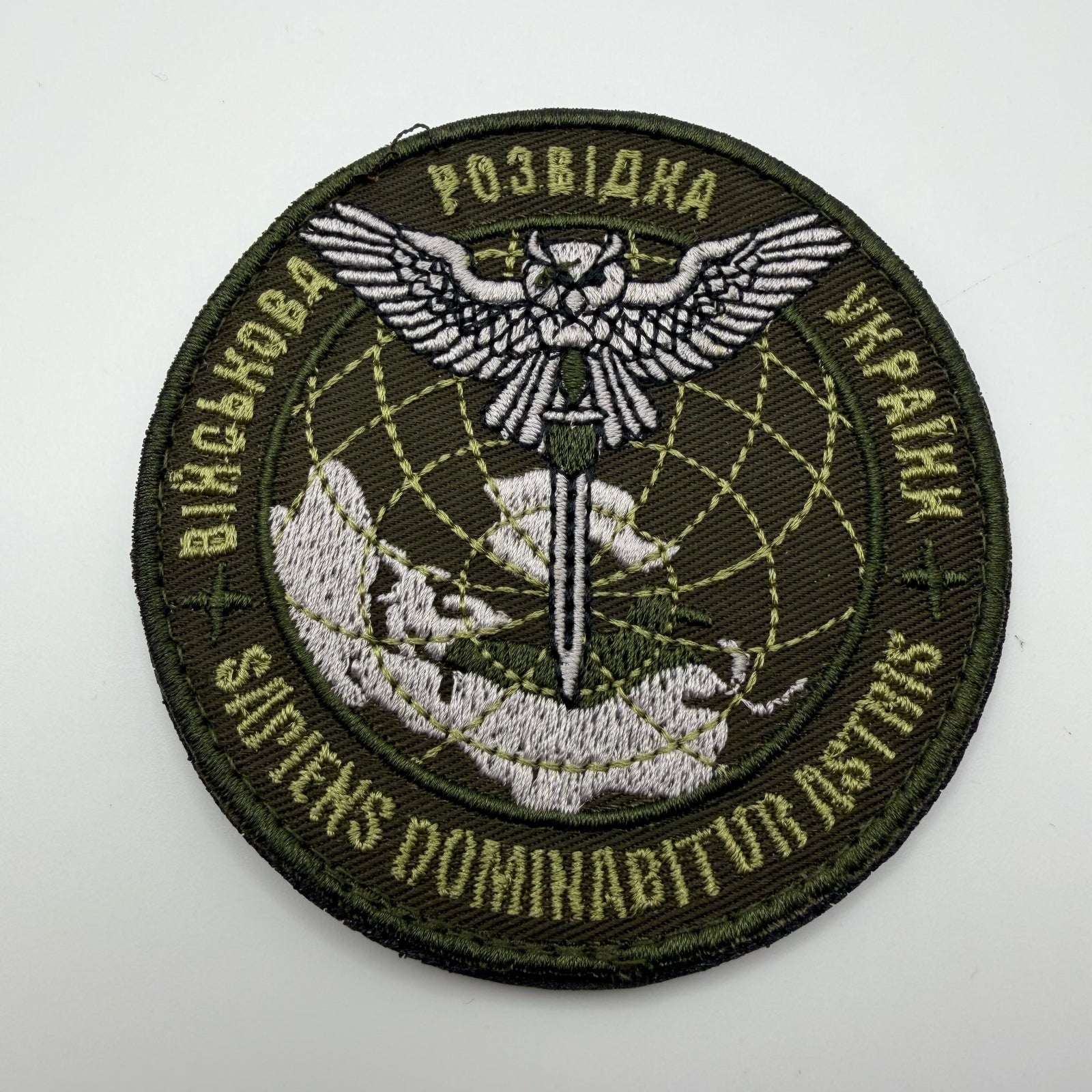 Circular patch with embroidered design on a white background
