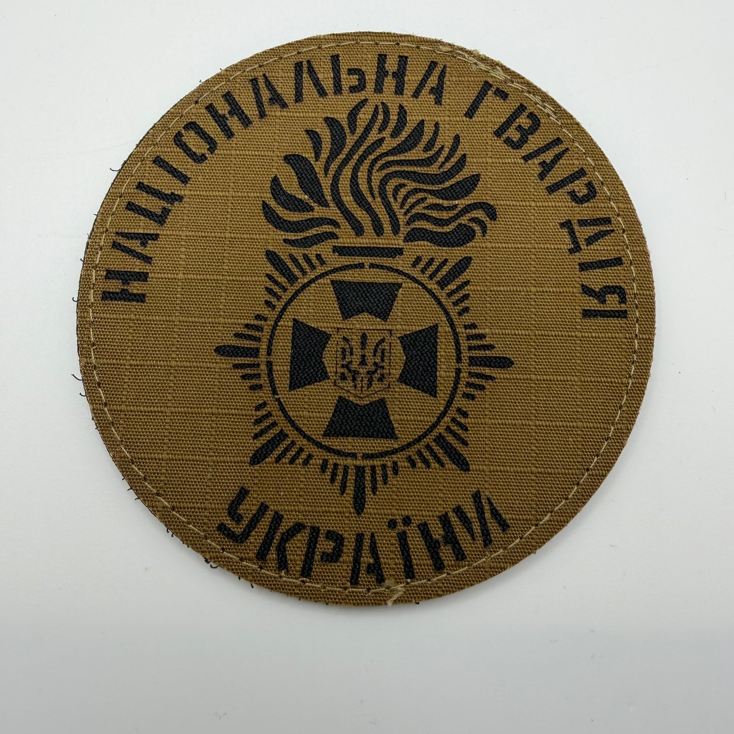 Brown patch with black text and emblem on a white background