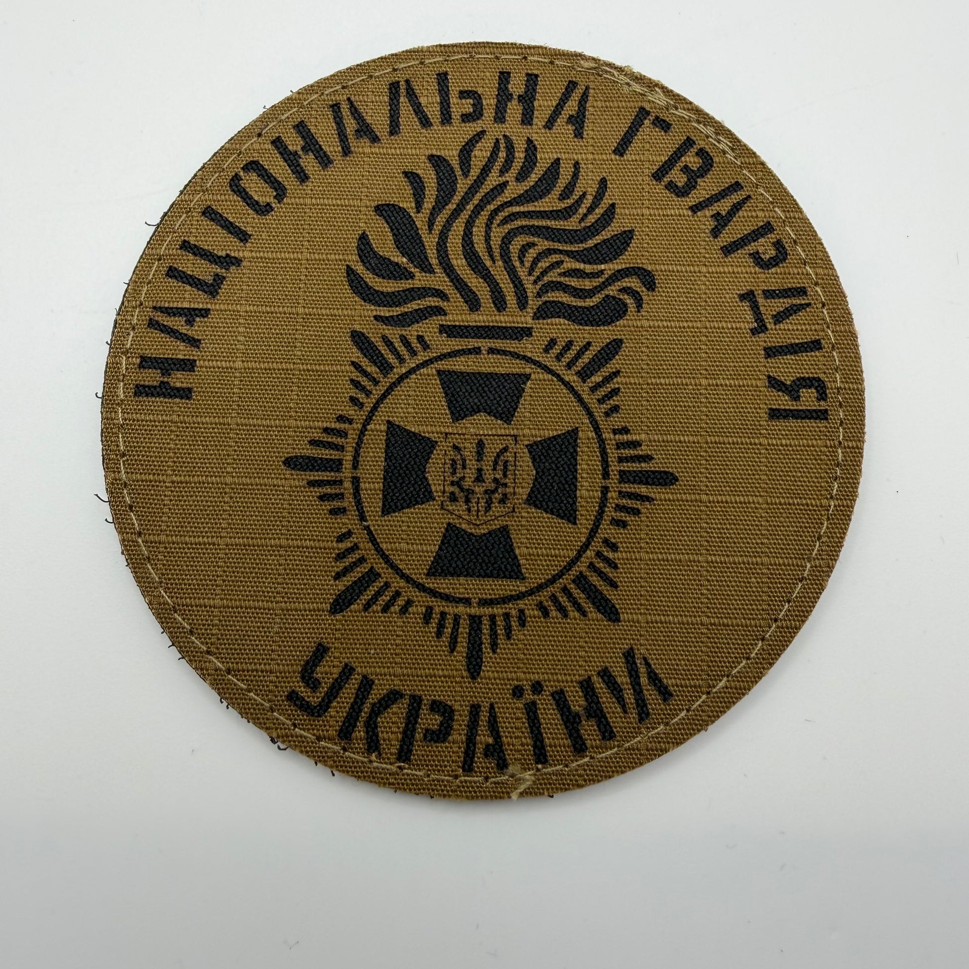 Brown patch with black text and emblem on a white background