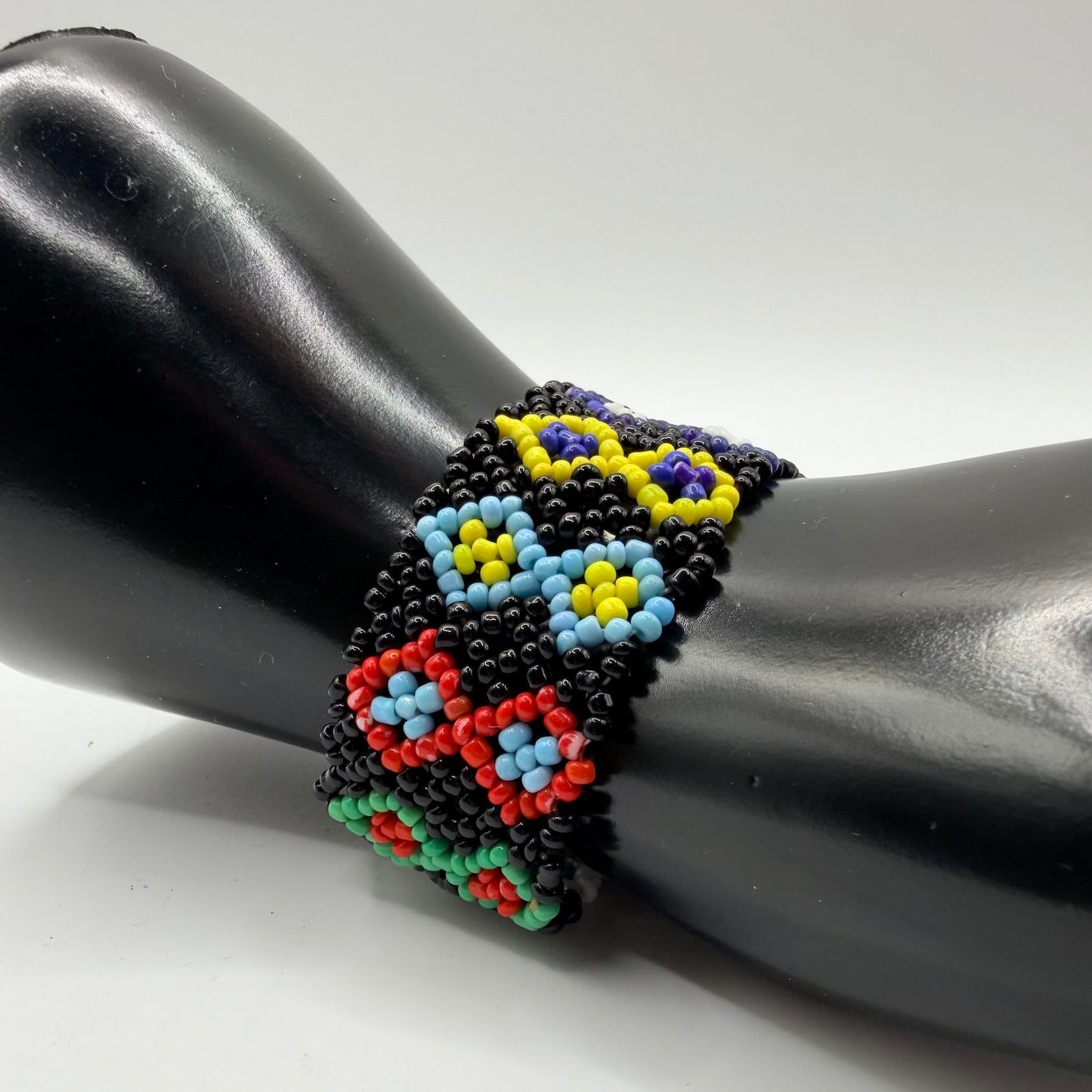 Beaded bracelet with colorful pattern on a black mannequin arm