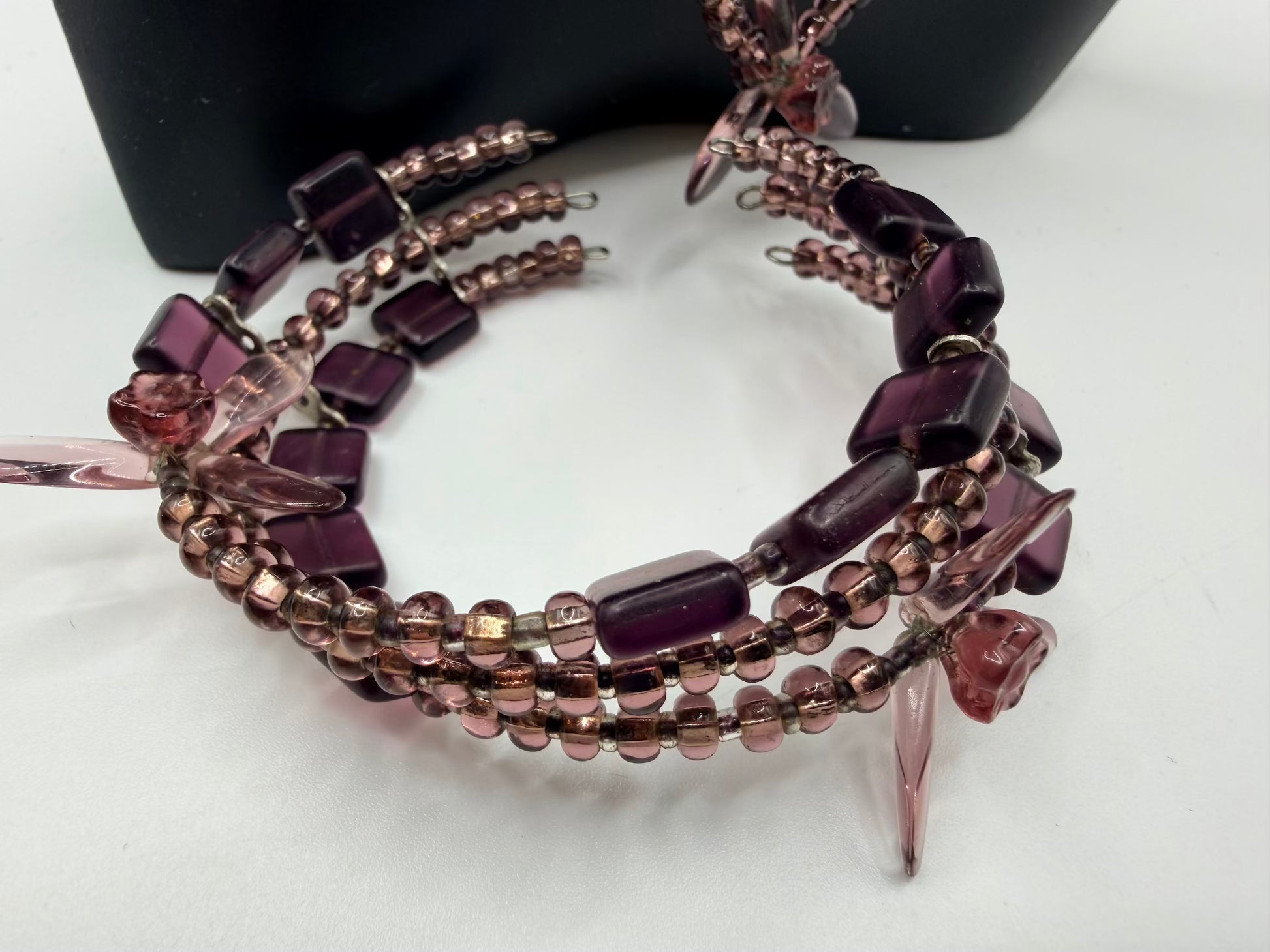 Beaded bracelet with purple and pink beads on a white surface