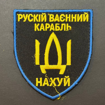 Embroidered patch with yellow text and emblem on a black background