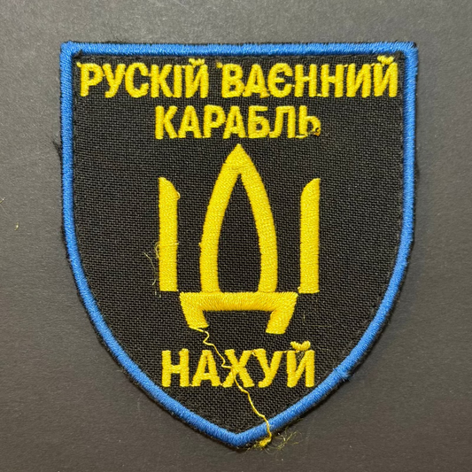 Embroidered patch with yellow text and emblem on a black background
