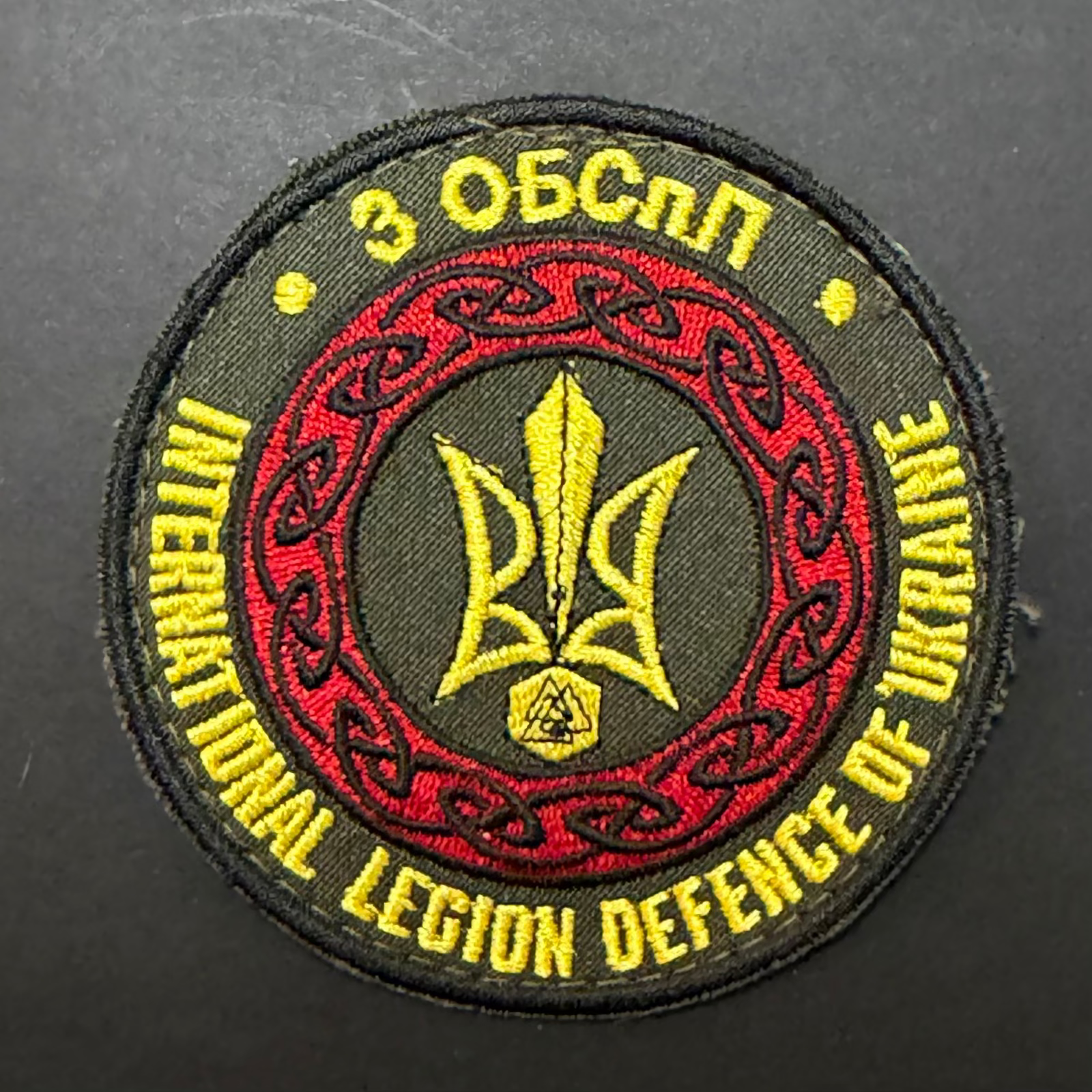 Embroidered patch with text and emblem on a dark background