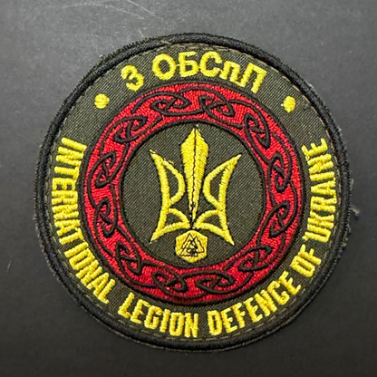 Embroidered patch with text and emblem on a dark background