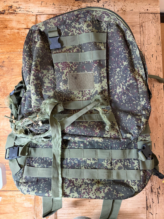 Camouflage backpack on a wooden surface