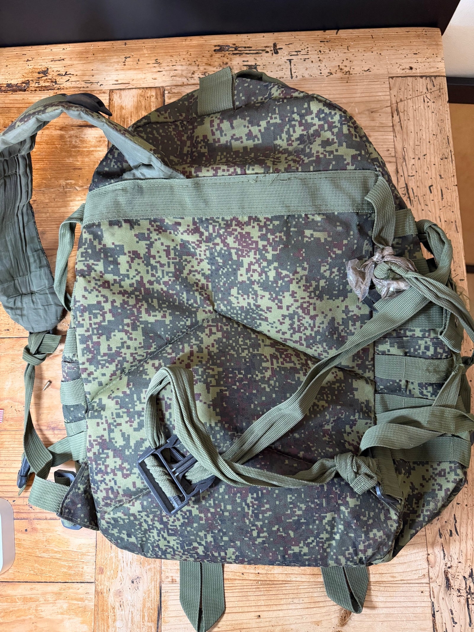 Camouflage backpack on a wooden surface