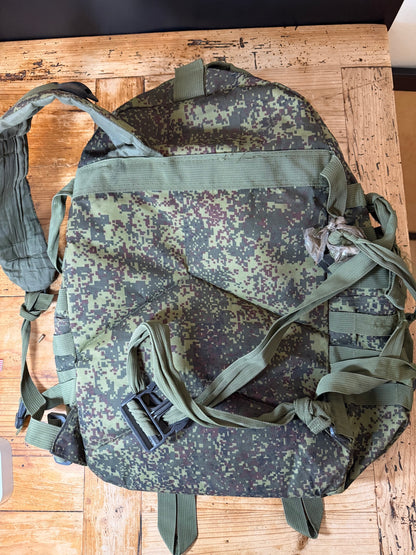 Camouflage backpack on a wooden surface