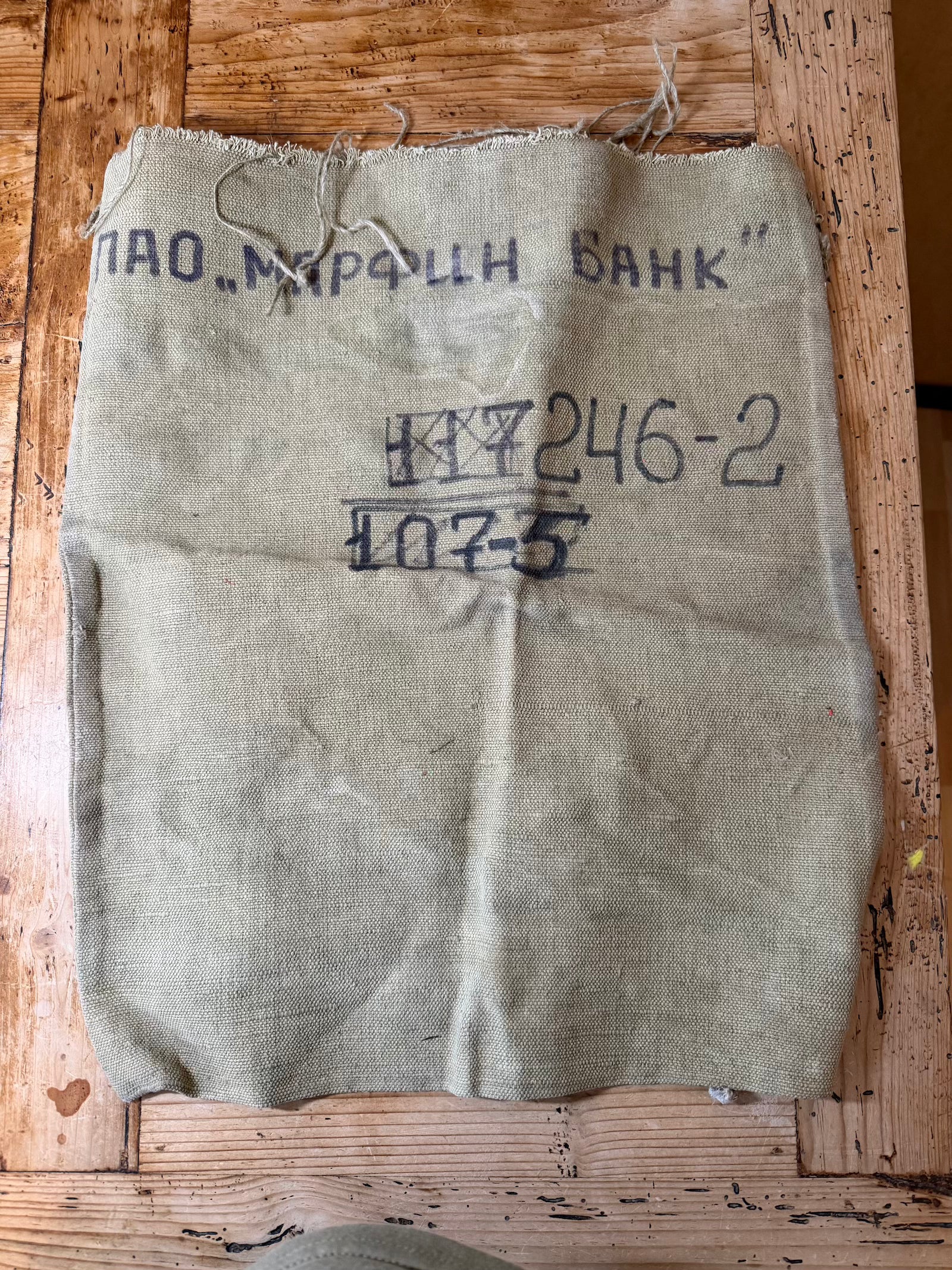 Vintage burlap bag with text on a wooden surface